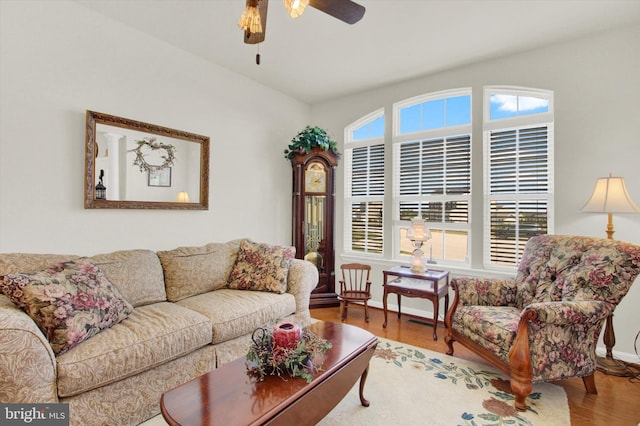 living area featuring plenty of natural light, baseboards, ceiling fan, and wood finished floors