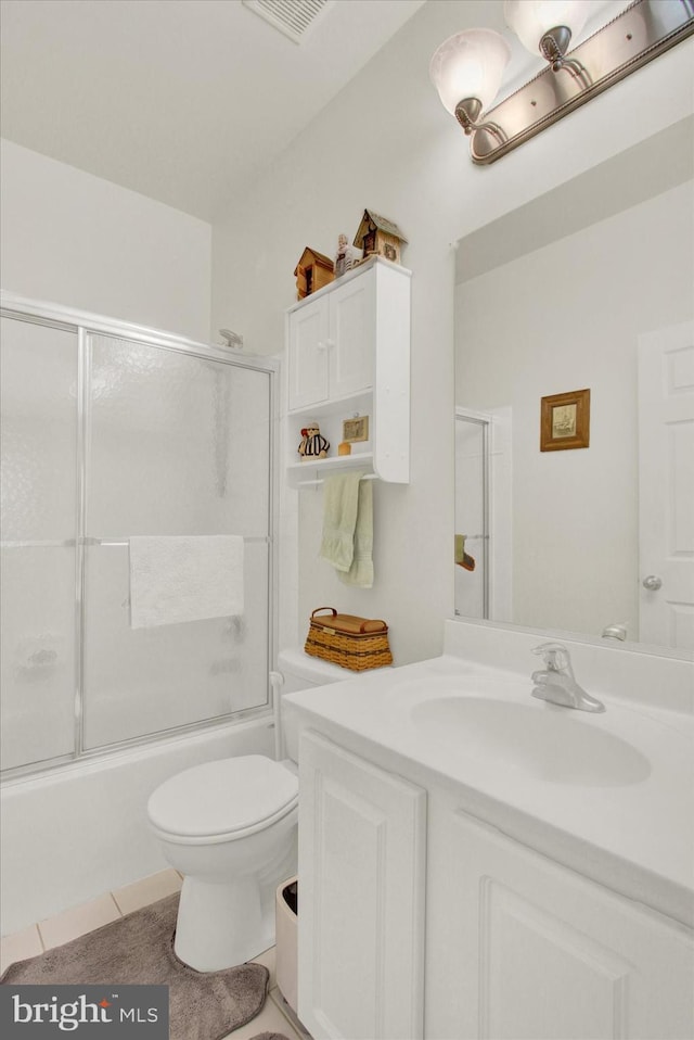 full bathroom featuring visible vents, toilet, tile patterned floors, combined bath / shower with glass door, and vanity