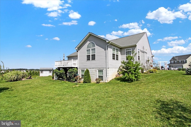 view of home's exterior with a wooden deck and a lawn