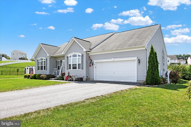 ranch-style house with a garage, a front lawn, driveway, and fence