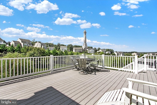 wooden terrace featuring outdoor dining space and a residential view