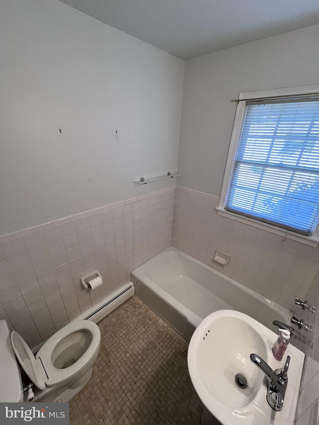 full bath with a sink, tile patterned flooring, a baseboard heating unit, tile walls, and a bathtub