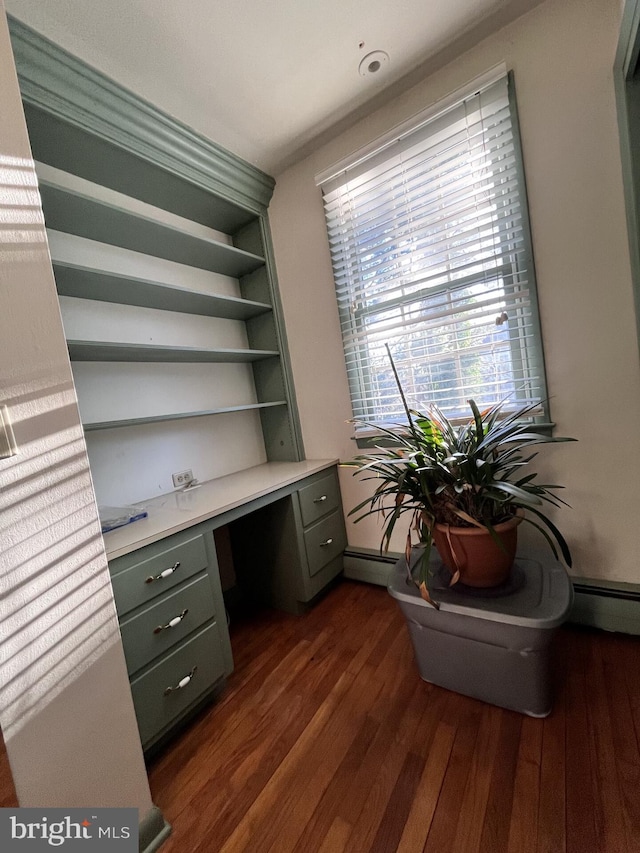 home office featuring dark wood-style floors, built in desk, and baseboard heating