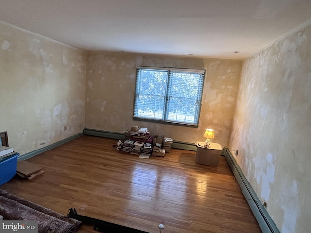 spare room with a baseboard radiator and wood finished floors