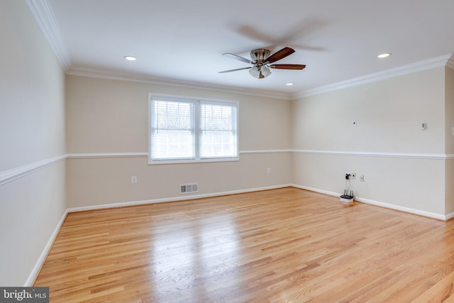 spare room featuring visible vents, ornamental molding, baseboards, and wood finished floors