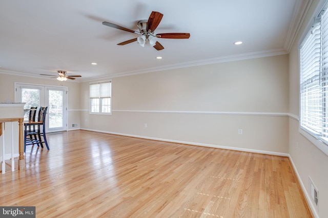 unfurnished living room with visible vents, light wood-style floors, and ornamental molding