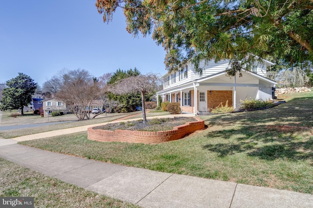 exterior space featuring a lawn and brick siding