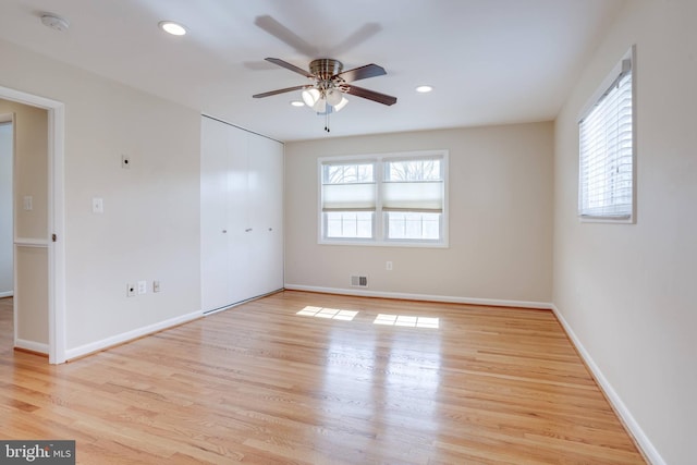 empty room with a wealth of natural light, visible vents, baseboards, and light wood-style floors