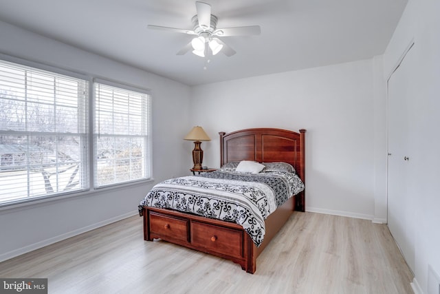 bedroom featuring light wood-style floors, baseboards, and ceiling fan