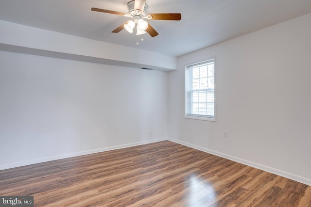 unfurnished room featuring visible vents, wood finished floors, baseboards, and ceiling fan