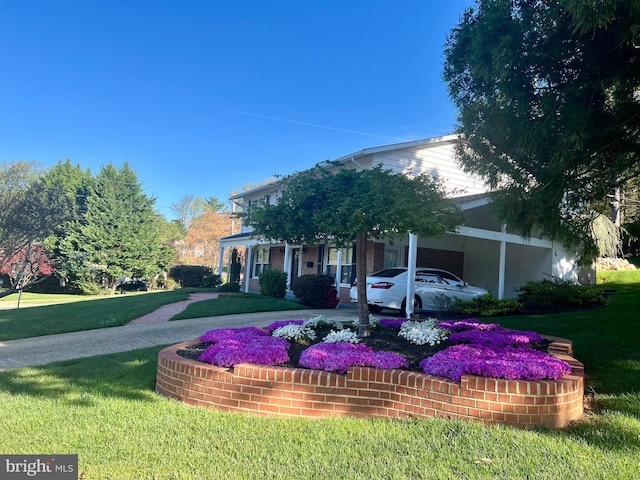 view of front of home with driveway, an attached carport, and a front lawn