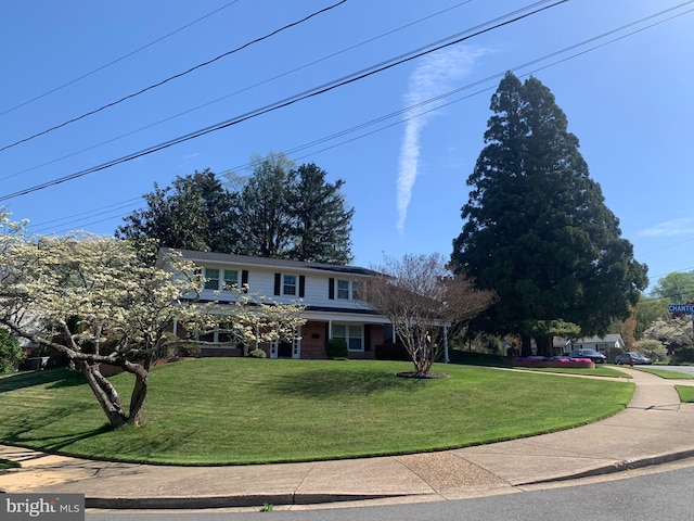 traditional-style home featuring brick siding and a front lawn