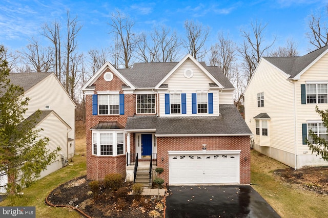 traditional home with aphalt driveway, brick siding, an attached garage, and a shingled roof