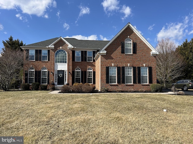 view of front of house featuring a front lawn and brick siding