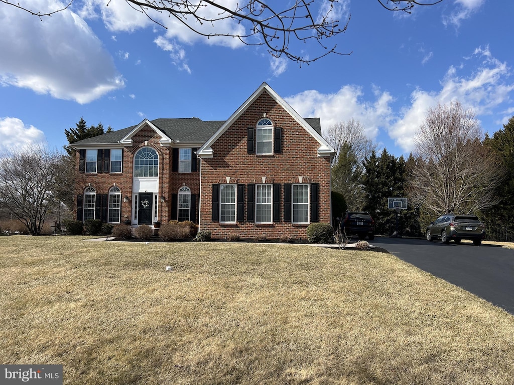 view of front of house with brick siding and a front lawn