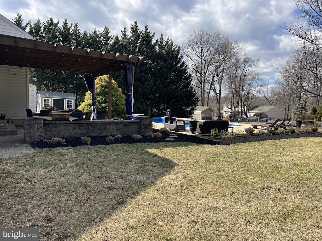 view of yard featuring a pergola, an outbuilding, an outdoor pool, and a patio area