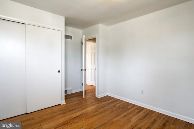 unfurnished bedroom with baseboards, visible vents, a closet, and light wood-type flooring