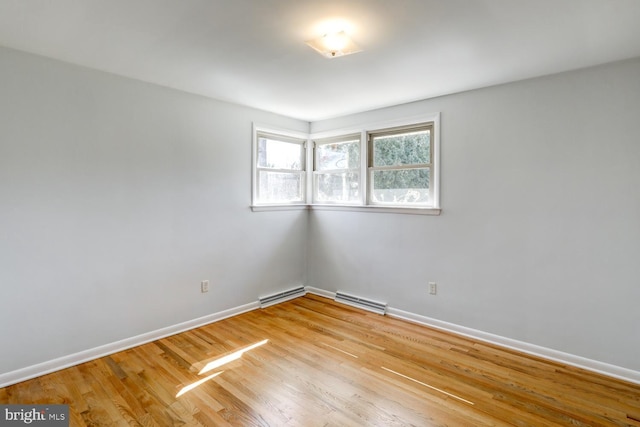 spare room featuring light wood-style flooring, baseboards, and visible vents