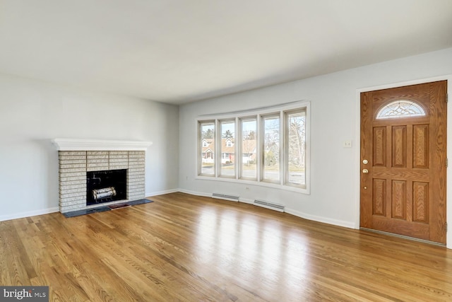 unfurnished living room featuring wood finished floors, a fireplace, and baseboards