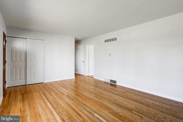 unfurnished bedroom with visible vents, baseboards, a closet, and light wood finished floors