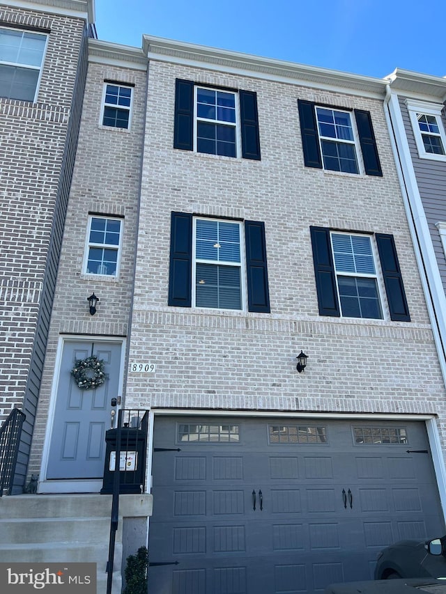 view of property featuring brick siding and an attached garage