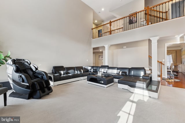 living room featuring recessed lighting, decorative columns, a high ceiling, and stairway