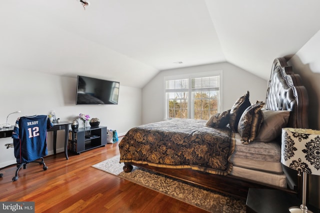 bedroom featuring lofted ceiling and wood finished floors