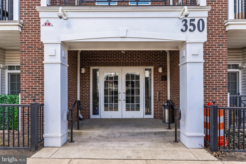 doorway to property featuring brick siding and french doors