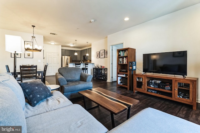 living room featuring a notable chandelier, visible vents, recessed lighting, and dark wood-style flooring