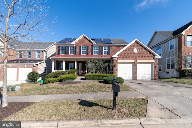 view of front facade with a garage, brick siding, solar panels, and concrete driveway