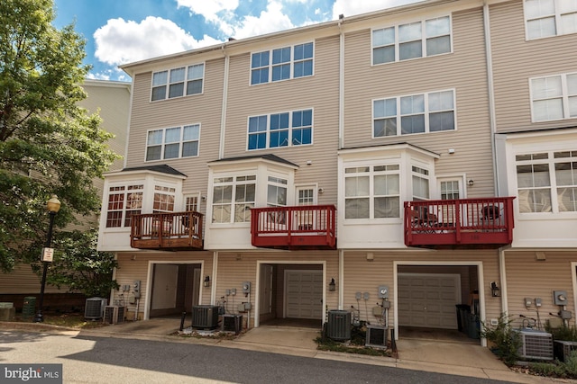 rear view of property featuring a garage and central AC