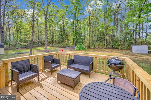 deck with outdoor lounge area, a fenced backyard, a shed, an outbuilding, and a lawn