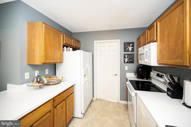 kitchen featuring light countertops, brown cabinetry, baseboards, and white appliances