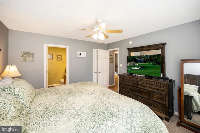 carpeted bedroom featuring ensuite bathroom, baseboards, and ceiling fan