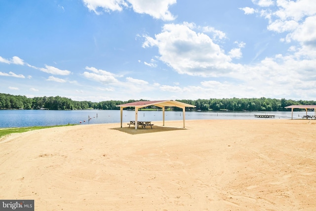 exterior space with a forest view, a gazebo, and a water view
