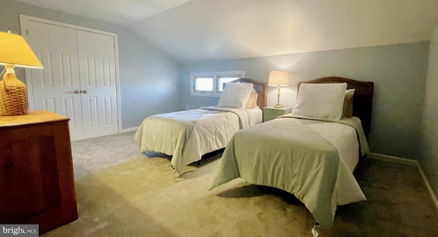 bedroom featuring a closet, baseboards, lofted ceiling, and carpet floors