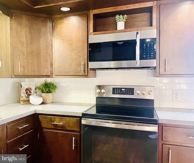 kitchen with light countertops, backsplash, and stainless steel appliances