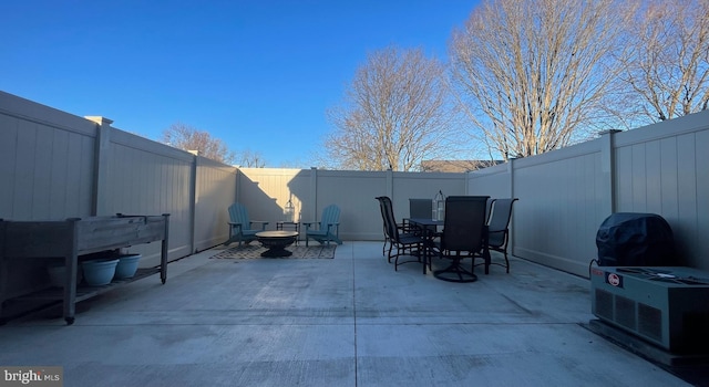 view of patio featuring a fenced backyard, outdoor dining space, and an outdoor fire pit