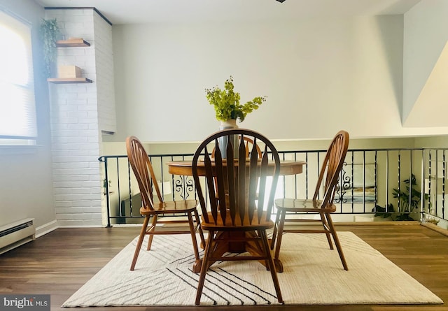 dining area featuring wood finished floors and a baseboard radiator