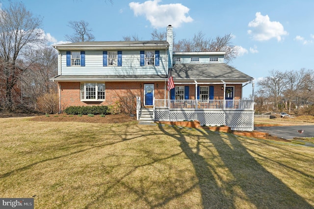 view of front of property with brick siding, a porch, and a front lawn