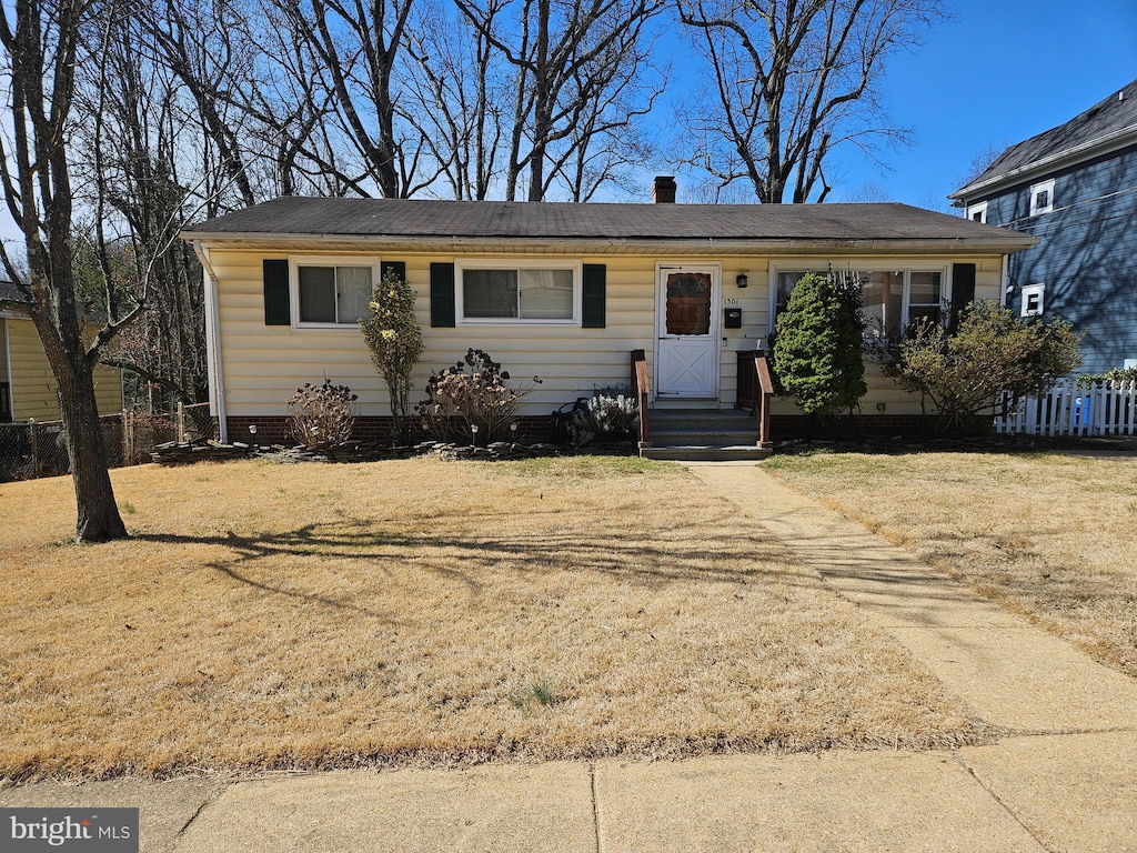 ranch-style home featuring a front lawn, fence, and crawl space