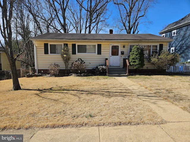 ranch-style home featuring a front lawn, fence, and crawl space