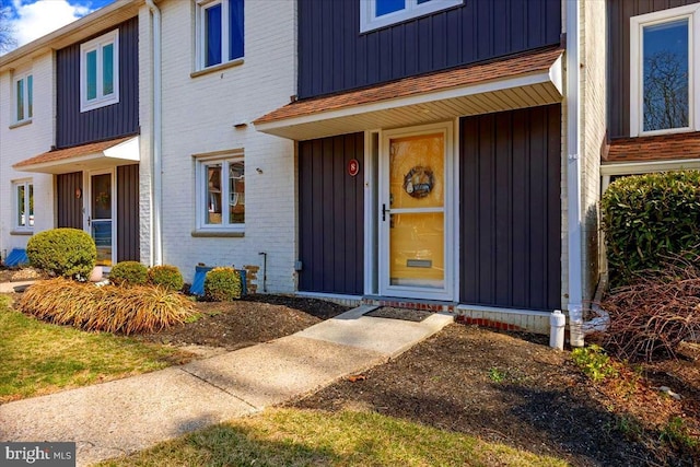 property entrance featuring brick siding and board and batten siding