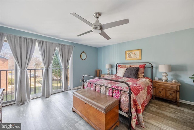 bedroom with a ceiling fan, access to outside, wood finished floors, and baseboards