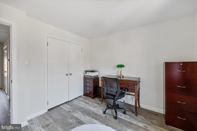 office space featuring baseboards and wood finished floors