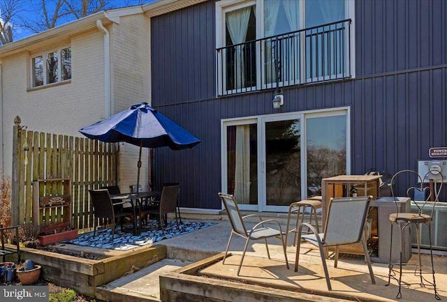 view of patio with outdoor dining space and fence