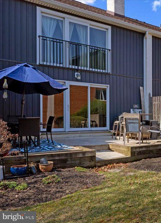 back of property featuring a chimney and a patio