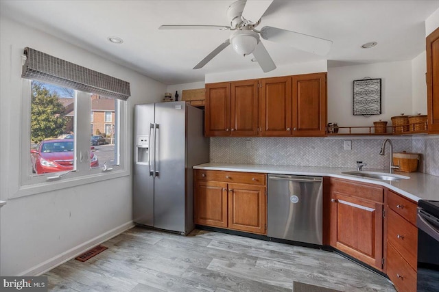 kitchen featuring a sink, light countertops, tasteful backsplash, and stainless steel appliances