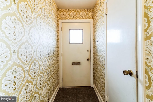 entryway with wallpapered walls and baseboards