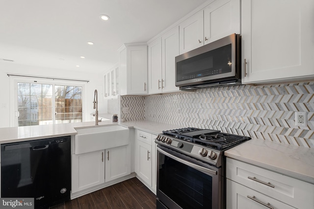 kitchen featuring a sink, tasteful backsplash, appliances with stainless steel finishes, and white cabinets